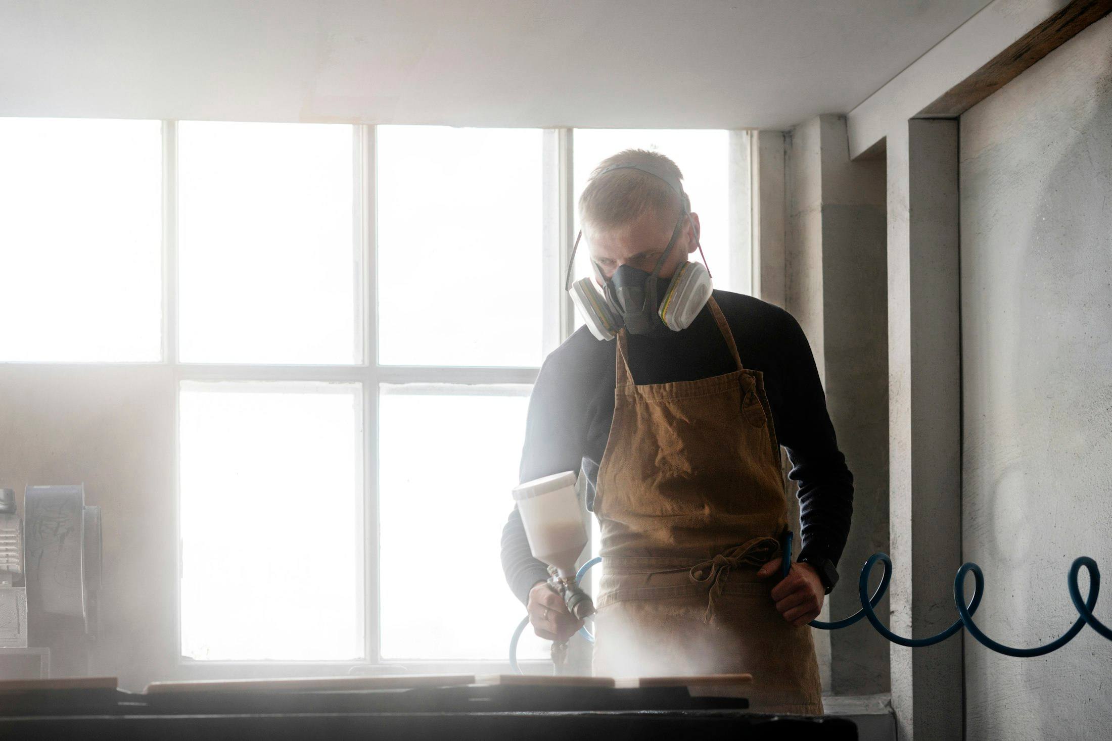 Worker in a respirator spraying a treatment